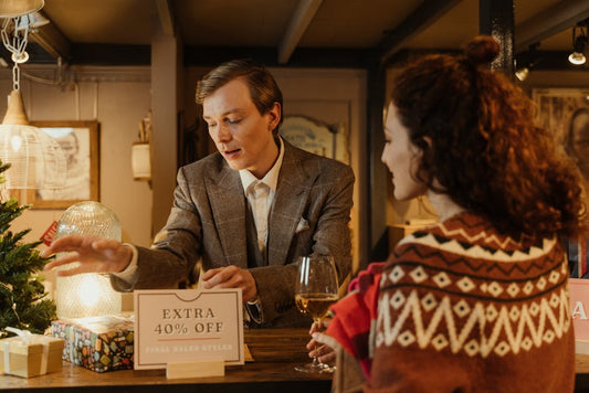 A man assisting a woman with shopping during a holiday sale in a store.